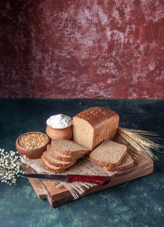 vertical-view-black-bread-slices-nude-color-towel-spikes-flower-cutting-boards-mixed-colors-background